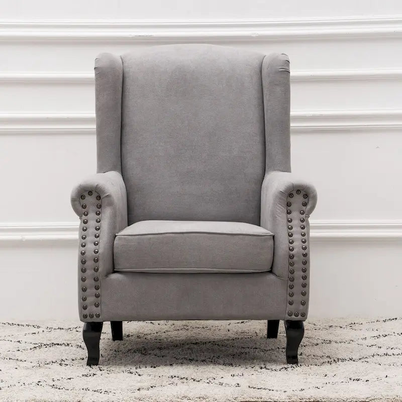 Fauteuil capitonné à oreilles avec clous de tapissier