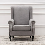 Fauteuil capitonné à oreilles avec clous de tapissier