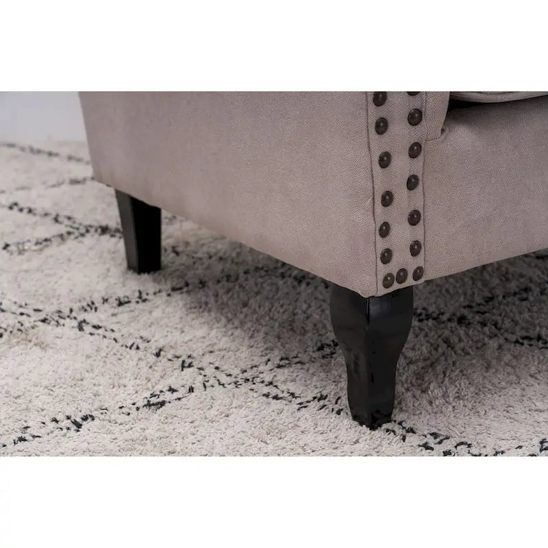 Fauteuil capitonné à oreilles avec clous de tapissier